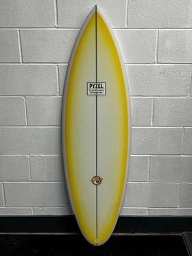 wildcat pyzel surfboard with bright yellow rails and deck fade.
