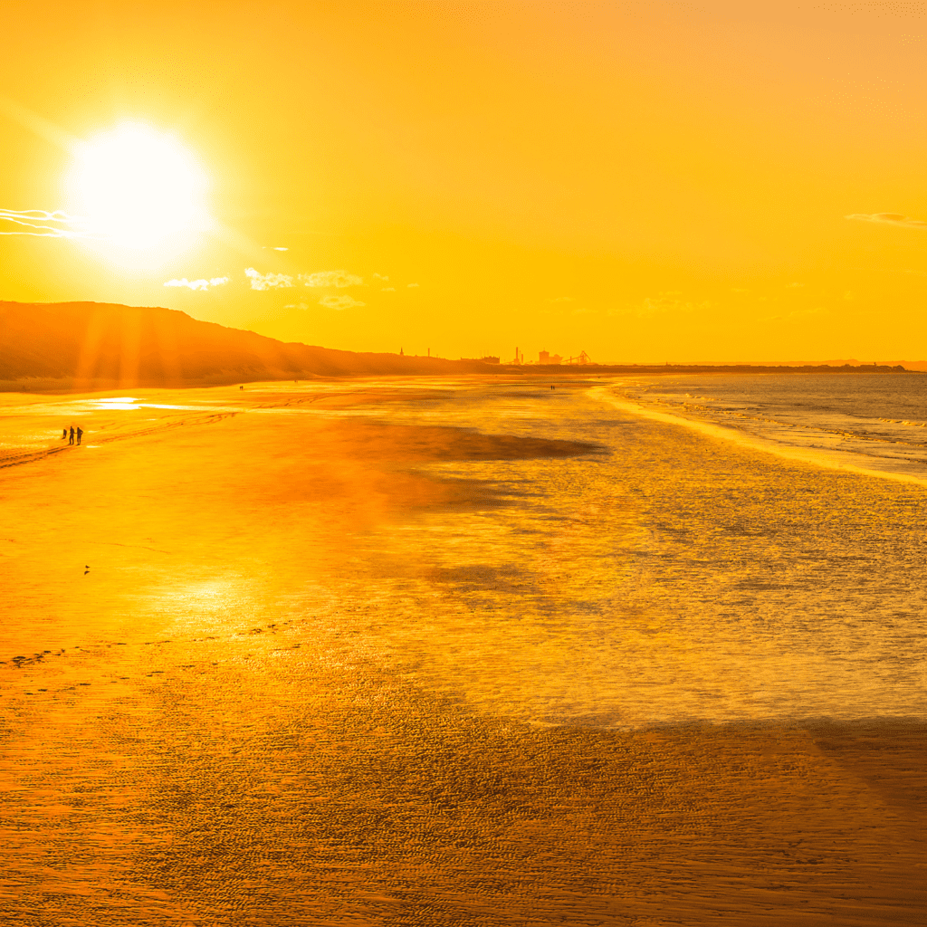 view of saltburn beach of waves breaking on the beach during golden hour