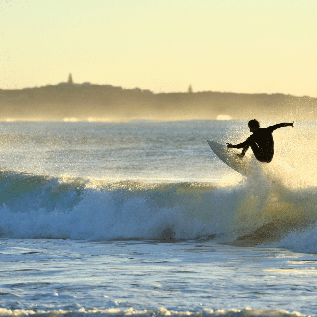 person surfing a wave during sunset